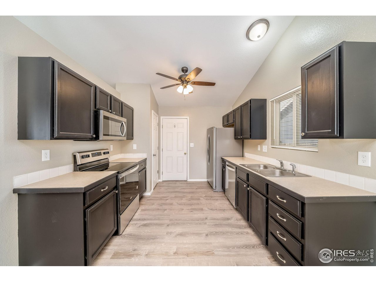 1021 East 25th St Road Greeley, CO 80631 - Photo 7 of 22 a large kitchen with cabinets stove oven and sink