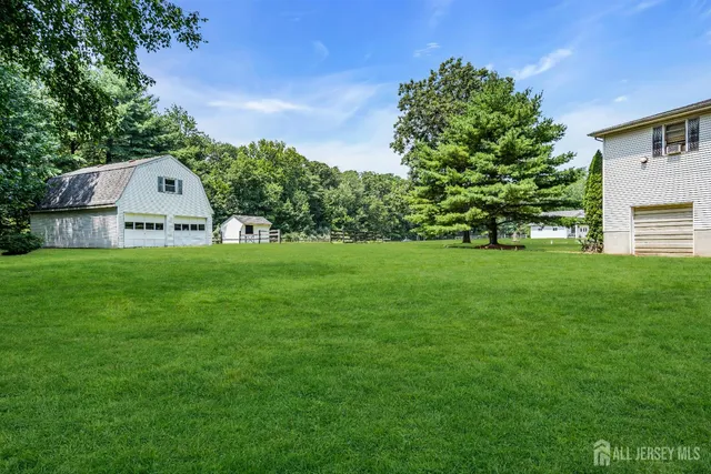 a view of a house with a big yard and large trees