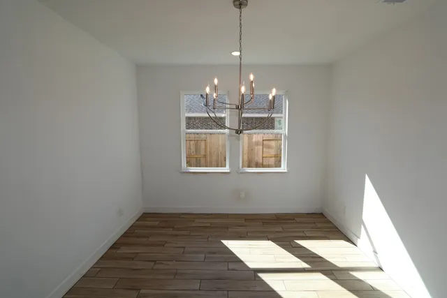 a large kitchen with stainless steel appliances a large counter top and a wooden floors