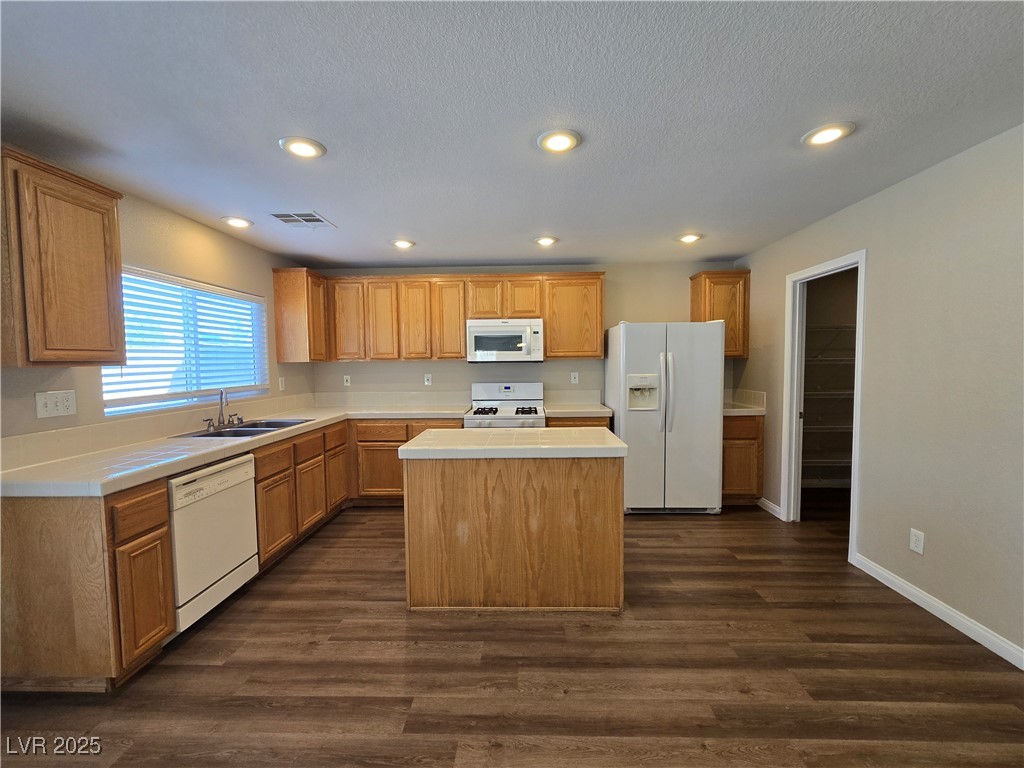 5508 Knotting Pass Las Vegas, NV 89131 - Photo 11 of 45 Kitchen featuring white appliances, light countertops, a kitchen island, dark wood-type flooring, and recessed lighting