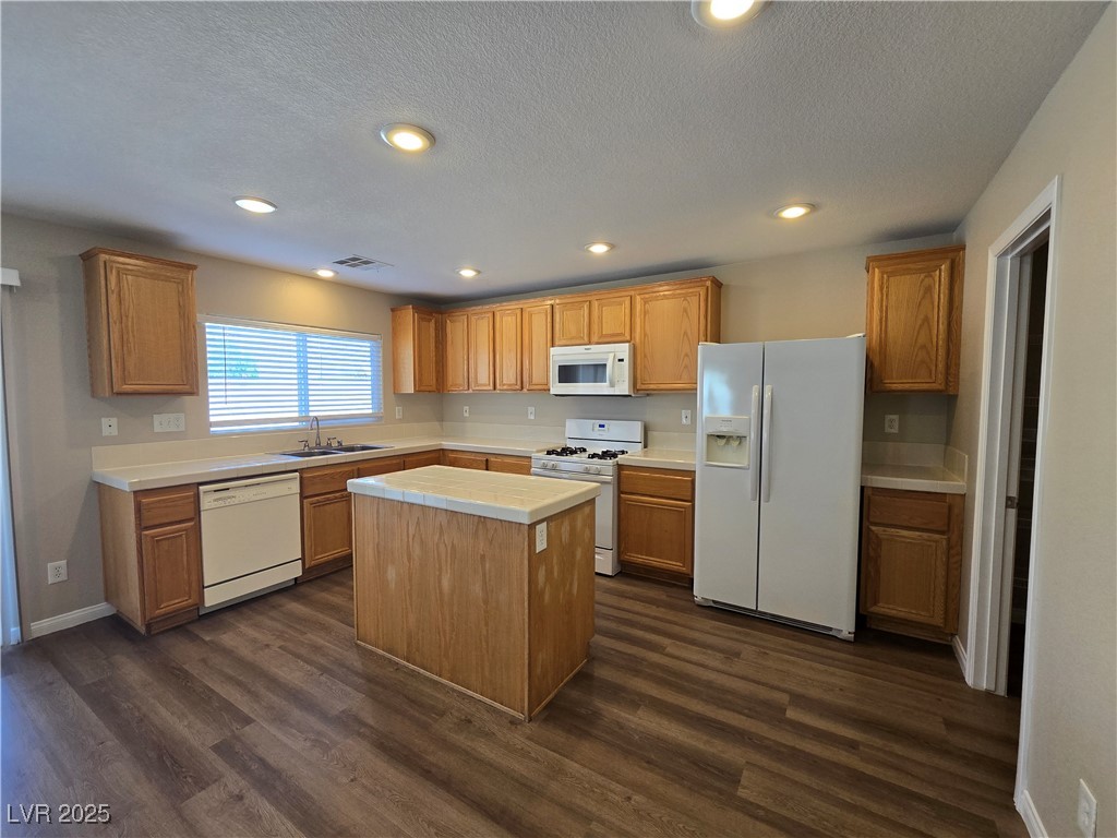 5508 Knotting Pass Las Vegas, NV 89131 - Photo 12 of 45 Kitchen with white appliances, a center island, dark wood-style flooring, brown cabinets, and recessed lighting