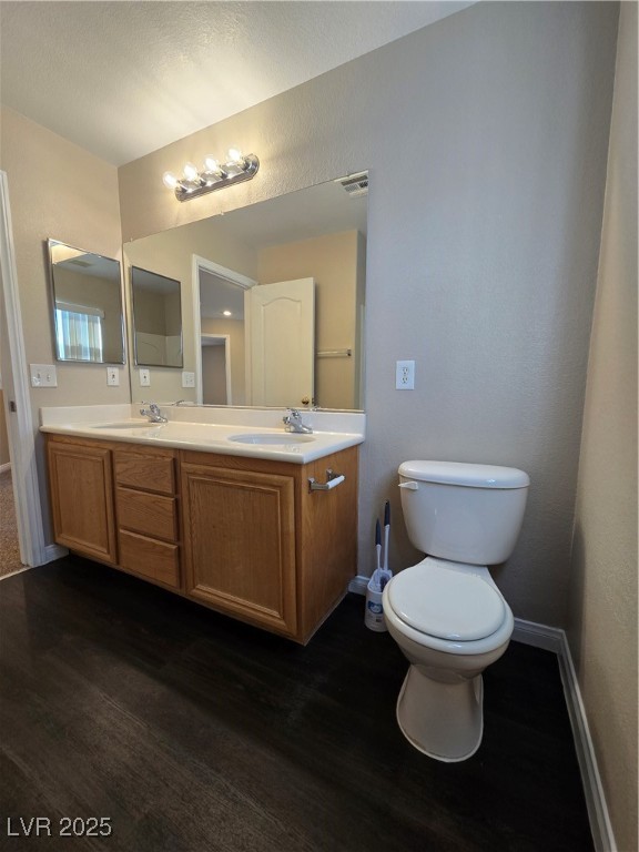 5508 Knotting Pass Las Vegas, NV 89131 - Photo 31 of 45 Full bathroom with double vanity, dark wood-style flooring, and a textured wall