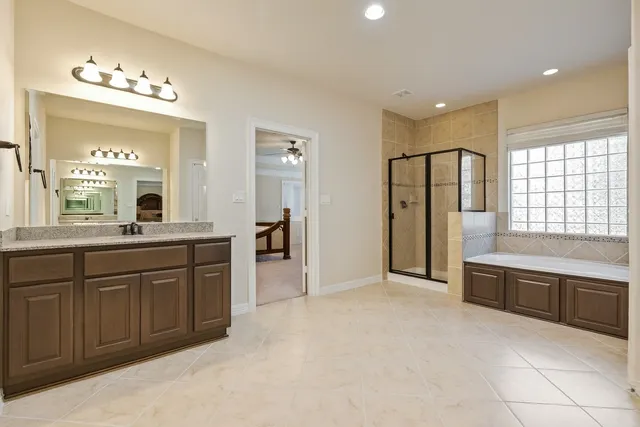 a view of a white house next to a yard with big trees