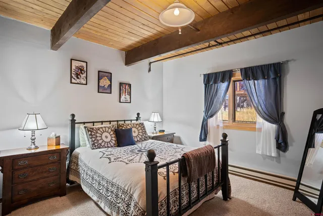 a bedroom with bed and wooden floor