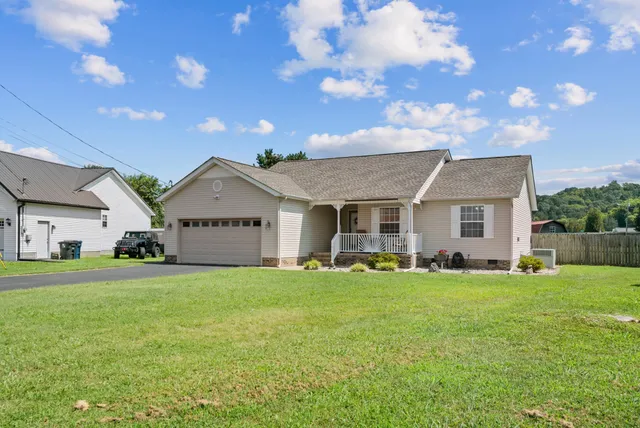 a view of a house with a big yard and large trees