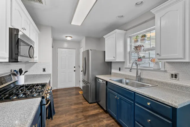 a kitchen with stainless steel appliances granite countertop a sink stove and refrigerator