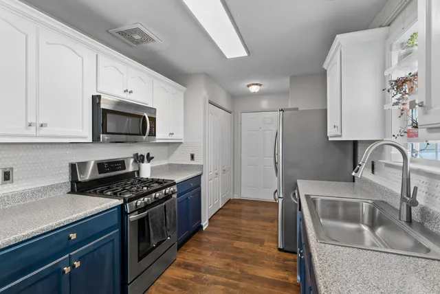 a kitchen with stainless steel appliances granite countertop a sink stove and refrigerator