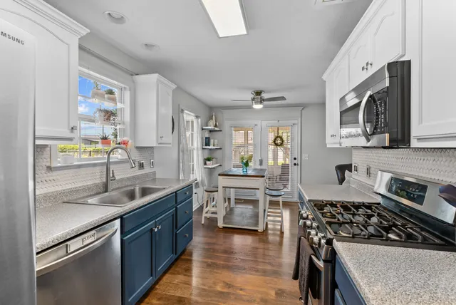 a kitchen with stainless steel appliances granite countertop a stove and a microwave