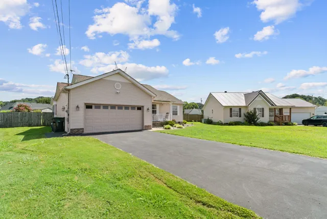 a front view of house with yard and garage