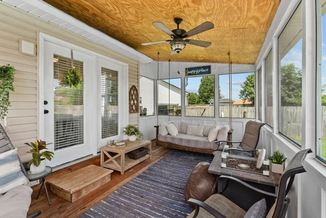 a living room with furniture a flat screen tv and a large window