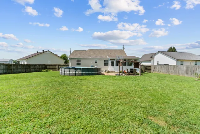 a view of a house with a big yard and a large tree