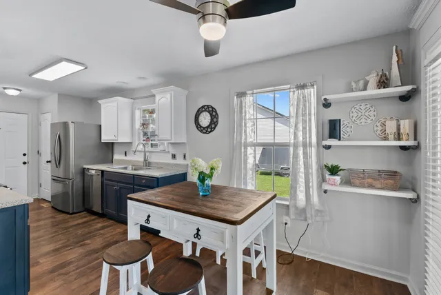 a living room with kitchen furniture and a wooden floor