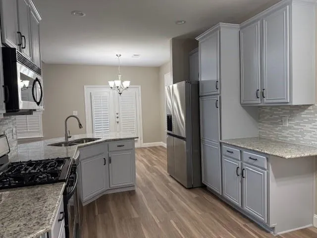 a kitchen with stainless steel appliances a sink stove and refrigerator