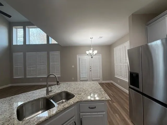 a kitchen with stainless steel appliances granite countertop a sink and a refrigerator