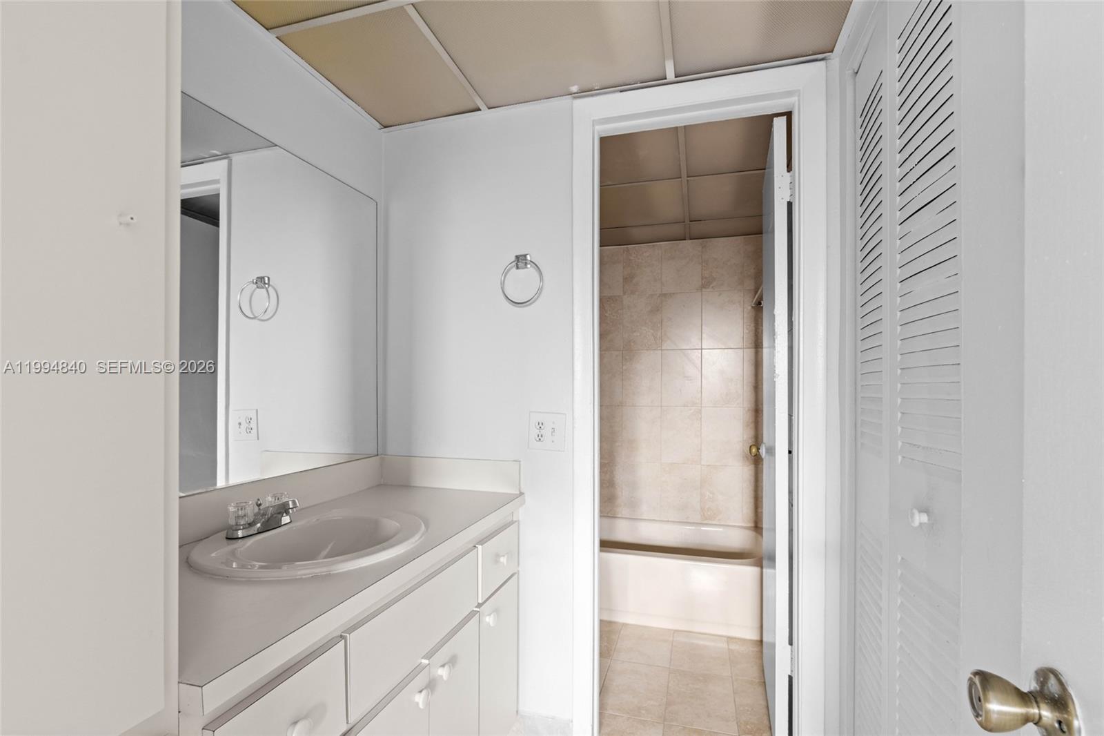 14250 Southwest 62nd Street, Unit 402 Miami, FL 33183 - Photo 15 of 25 a bathroom with a sink and mirror