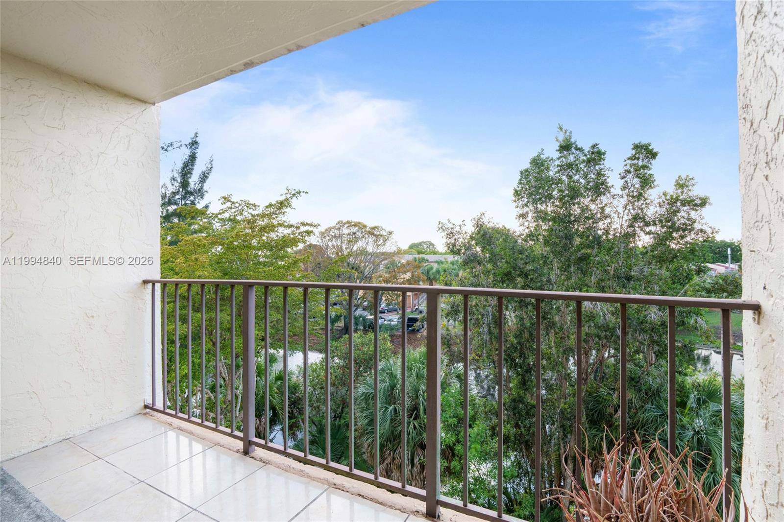 14250 Southwest 62nd Street, Unit 402 Miami, FL 33183 - Photo 20 of 25 a balcony with trees in front of it