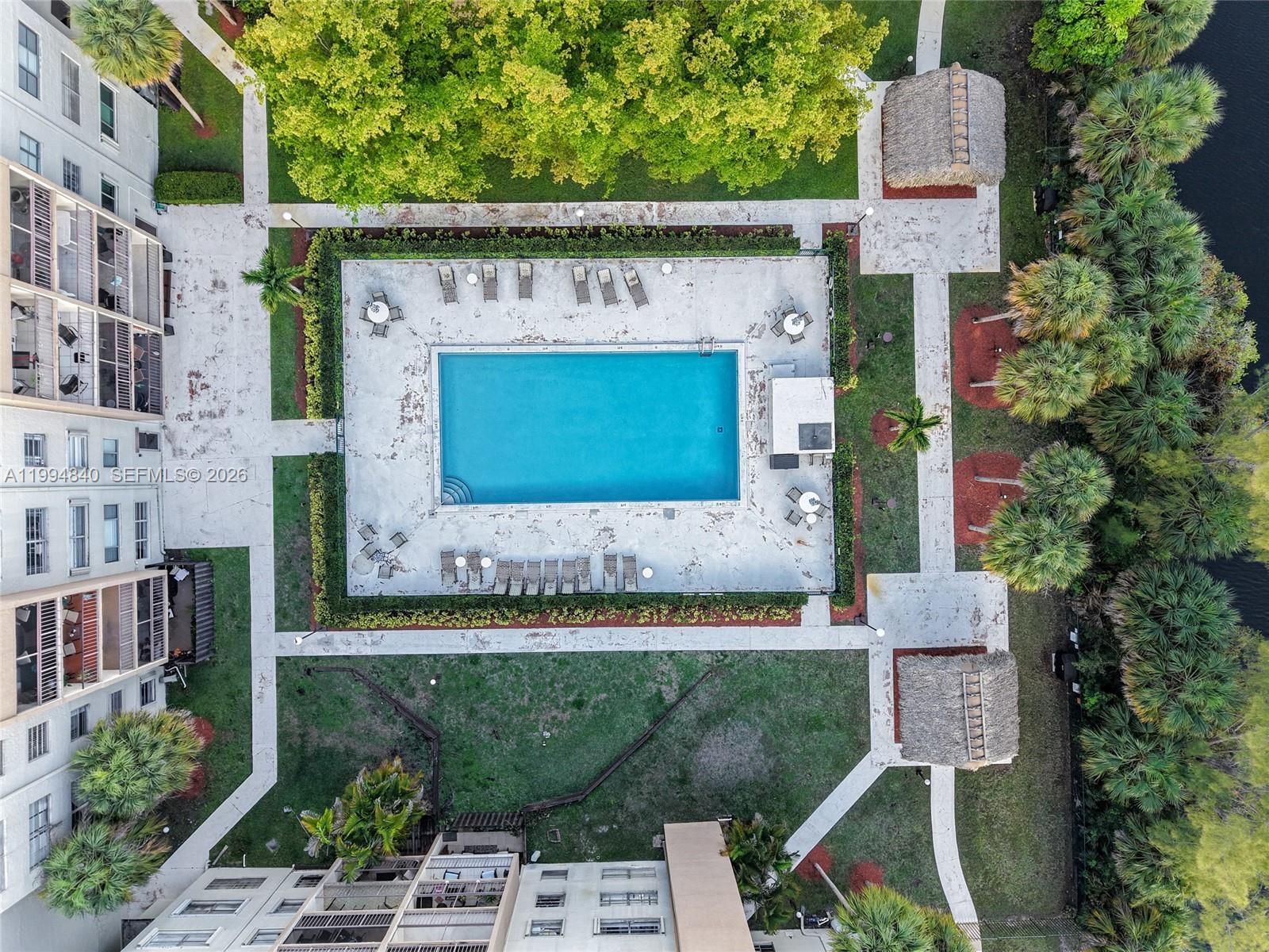 14250 Southwest 62nd Street, Unit 402 Miami, FL 33183 - Photo 21 of 25 a front view of a house with a garden and a tree