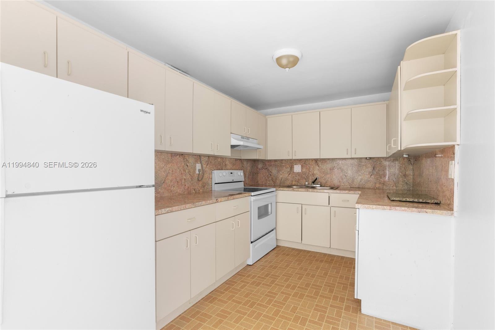 14250 Southwest 62nd Street, Unit 402 Miami, FL 33183 - Photo 10 of 25 a kitchen with a refrigerator sink and cabinets