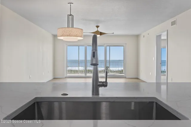 a kitchen with granite countertop a sink and white cabinets