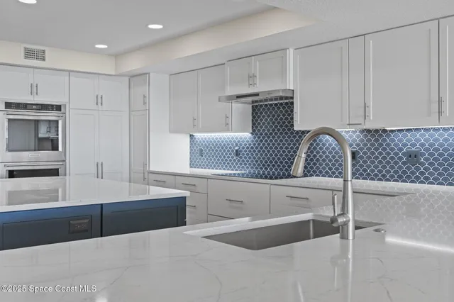a kitchen with stainless steel appliances granite countertop a sink and a refrigerator