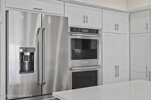a kitchen with a sink dishwasher and a stove with wooden floor