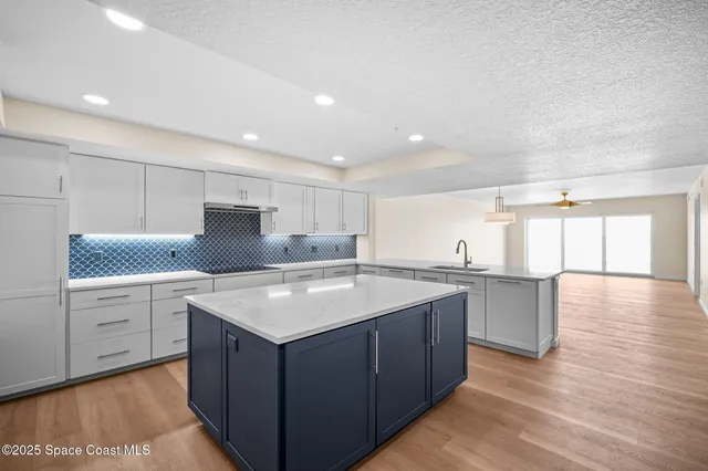 a kitchen with a sink a refrigerator and cabinets