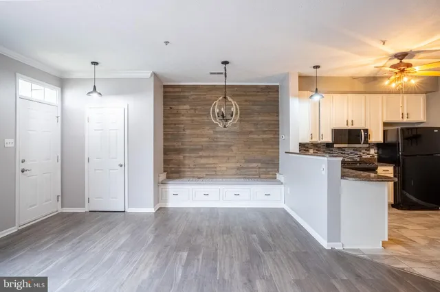 a kitchen with stainless steel appliances a refrigerator and a wooden floor