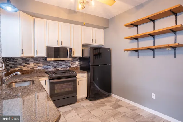 a kitchen with stainless steel appliances granite countertop a refrigerator stove and sink