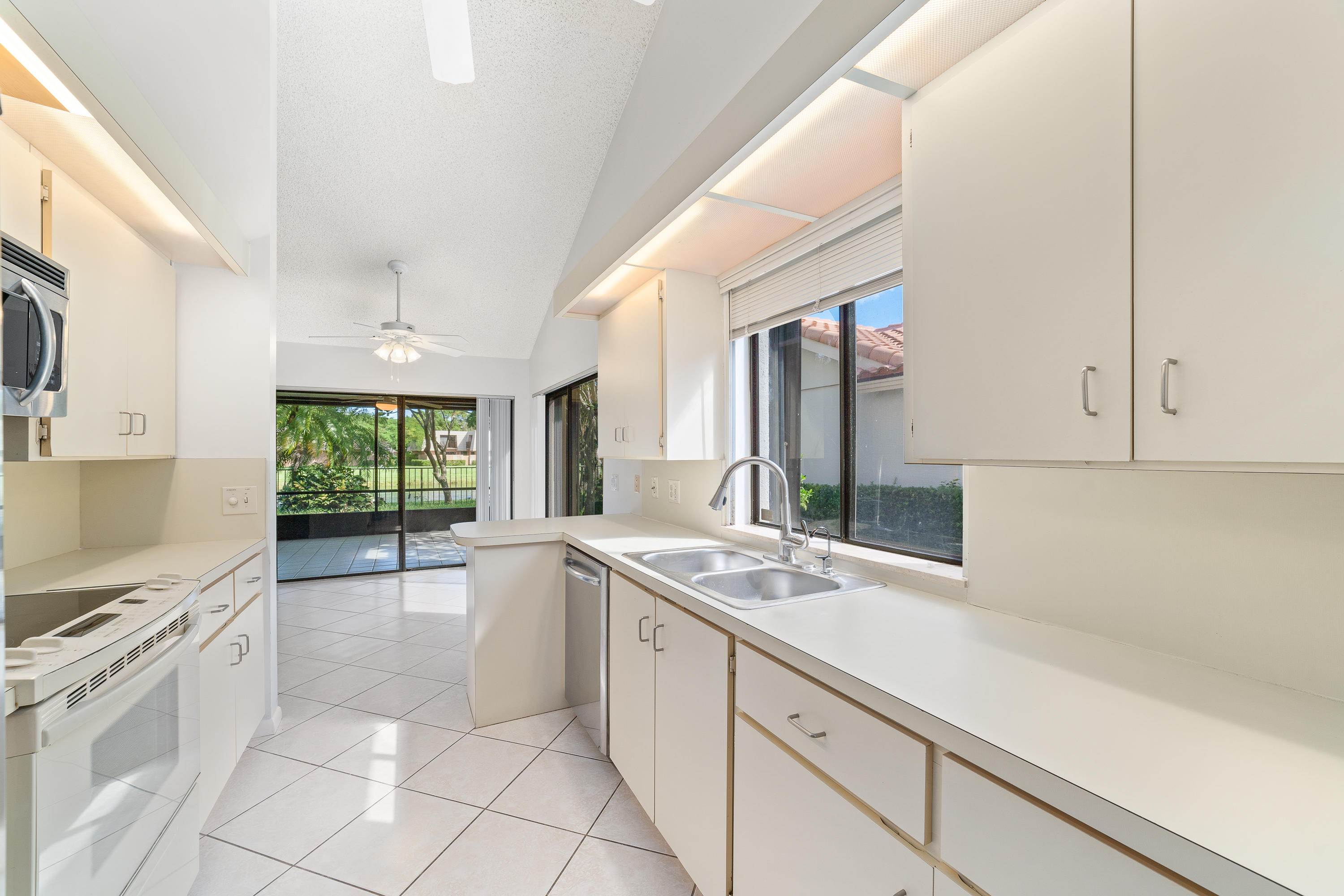 2630 Mohawk Circle West Palm Beach, FL 33409 - Photo 16 of 39 a large white kitchen with a sink and cabinets
