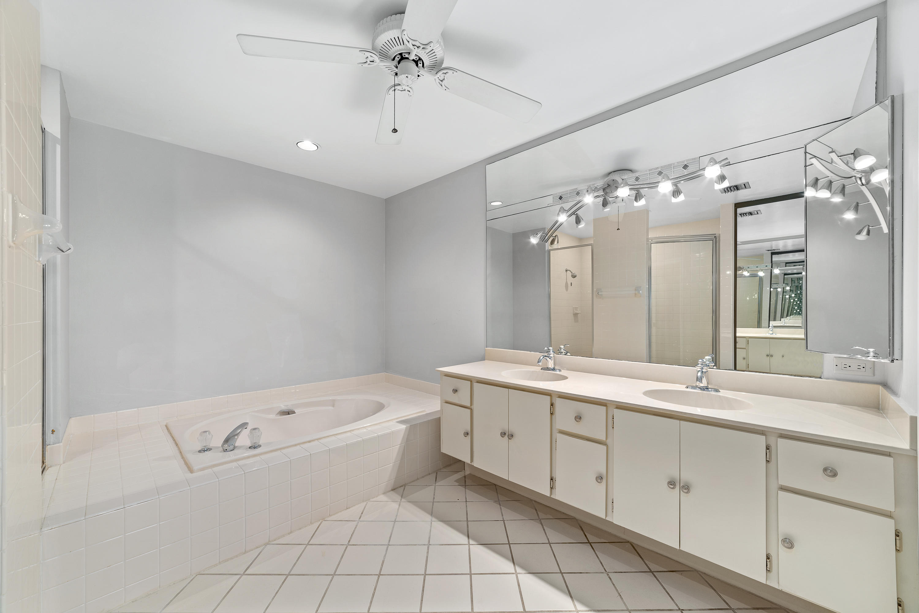 2630 Mohawk Circle West Palm Beach, FL 33409 - Photo 21 of 39 a bathroom with a granite countertop sink a large mirror and a bathtub