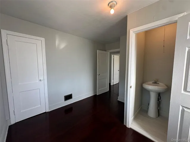an empty room with wooden floor and closet