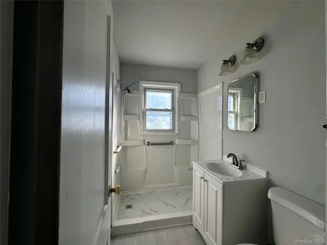 an empty room with wooden floor closet and windows