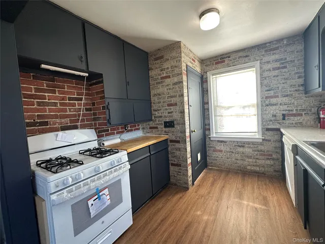 a kitchen with granite countertop a stove a sink and wooden floor