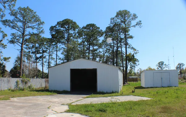 a yellow house with tree in the background