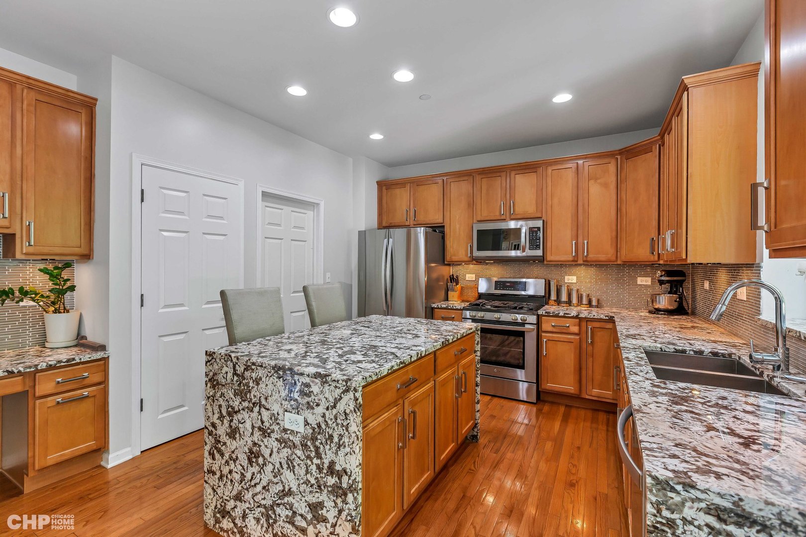917 Blue Ridge Drive Streamwood, IL 60107 - Photo 9 of 46 a kitchen with stainless steel appliances granite countertop a stove top oven a sink dishwasher and a refrigerator with wooden floor
