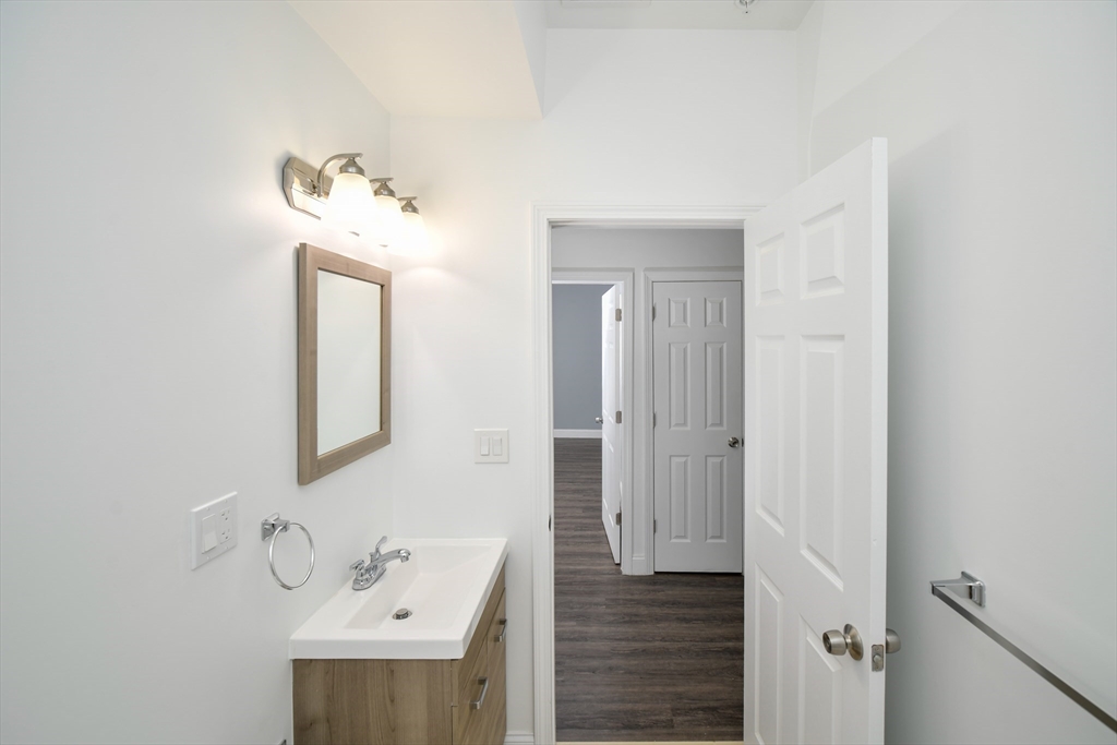 55 Dale Street, Unit 3 Boston, MA 02119 - Photo 11 of 24 a bathroom with a sink a mirror and vanity