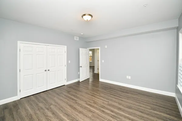 a view of an empty room with wooden floor