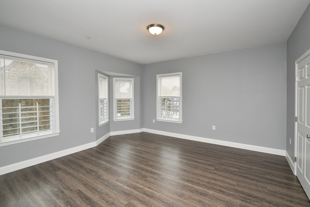 55 Dale Street, Unit 3 Boston, MA 02119 - Photo 14 of 24 a view of an empty room with wooden floor and a window