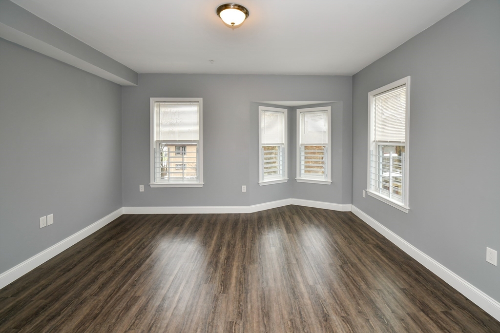 55 Dale Street, Unit 3 Boston, MA 02119 - Photo 15 of 24 an empty room with wooden floor and windows