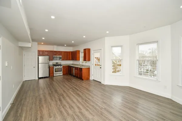 a living room with stainless steel appliances kitchen island a large counter top and floors