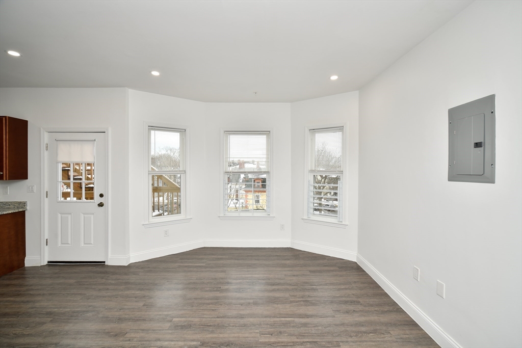 55 Dale Street, Unit 3 Boston, MA 02119 - Photo 8 of 24 a view of an empty room with wooden floor and a window
