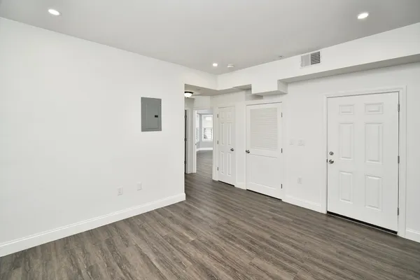a view of an empty room with wooden floor