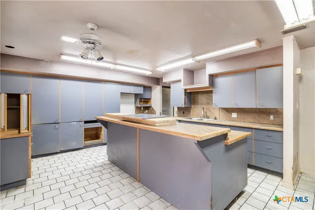 a large kitchen with stainless steel appliances kitchen island granite countertop a sink and cabinets