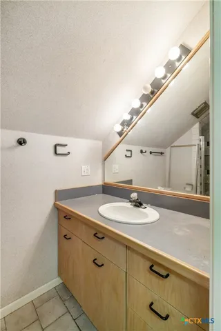 a bathroom with a granite countertop sink and a mirror