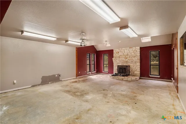 an empty room with fireplace and windows