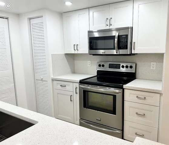 a kitchen with stainless steel appliances a stove a microwave and cabinets