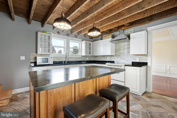 a view of a kitchen with kitchen island a counter top space a sink and a window