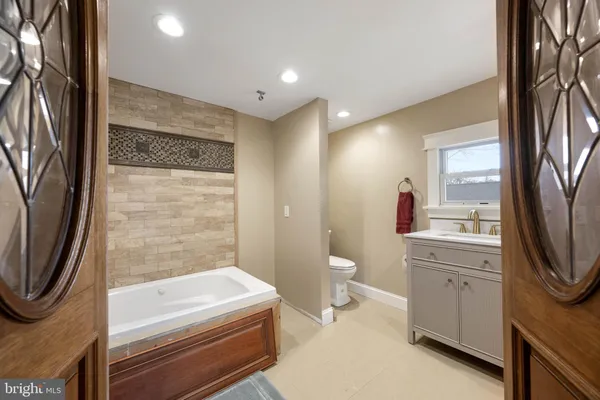 a bathroom with a granite countertop sink a toilet and shower