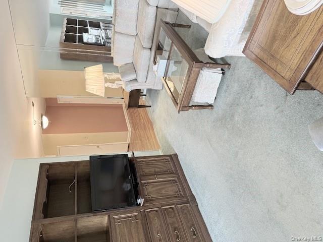 210-15 23rd Avenue, Unit 4E Queens, NY 11360 - Photo 4 of 8 a living room with furniture and a flat screen tv