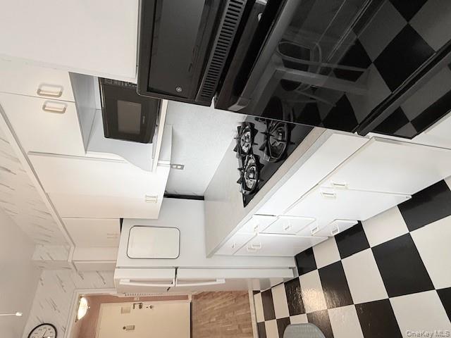 210-15 23rd Avenue, Unit 4E Queens, NY 11360 - Photo 6 of 8 a kitchen with a stove and a refrigerator